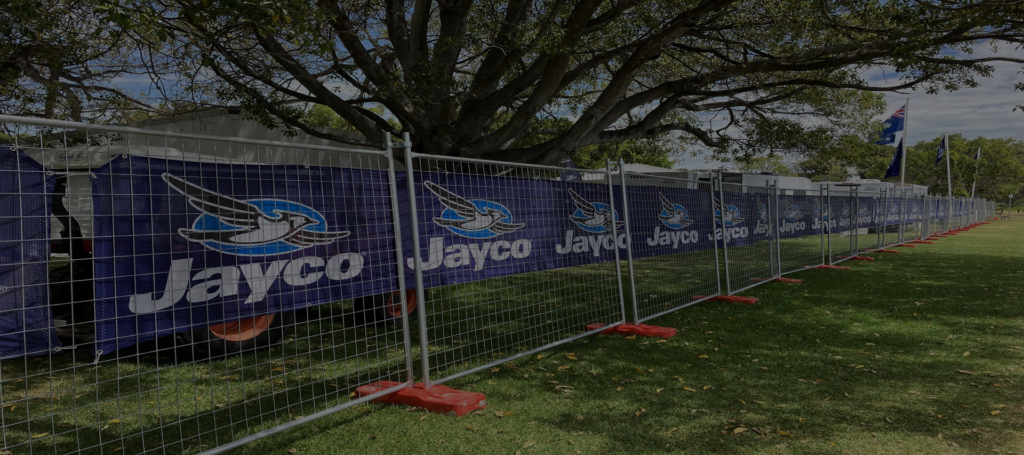 Temporary fencing displaying Jayco branded banners, securely enclosing a section of a park during a Perth event.