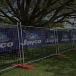 Temporary fencing displaying Jayco branded banners, securely enclosing a section of a park during a Perth event.