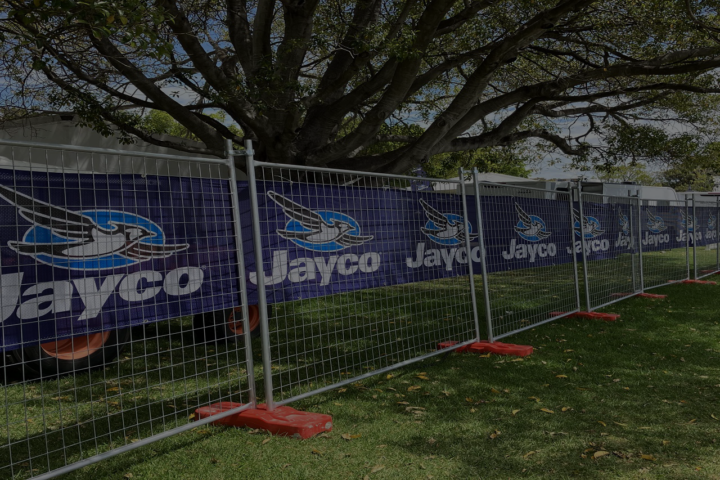 Temporary fencing displaying Jayco branded banners, securely enclosing a section of a park during a Perth event.