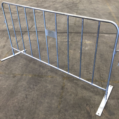 Temporary crowd control barriers set up on a concrete surface in an indoor area.